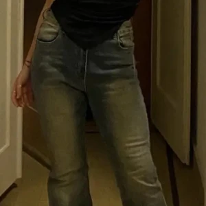 Blå bootcut jeans med hög midja - Snygga blå jeans med bootcut-modell och hög midja. Jeansen har klassisk femficksdesign och är tillverkade i denim. Perfekta för dig som gillar en retroinspirerad look med utsvängda ben.