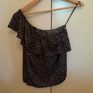 Blommig offshoulder topp Twist & Tango - Supersöt svart offshoulder topp från Twist & Tango med vitt blommönster. Använd fåtal gånger.