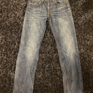 Blå Lee jeans - Snygga blå jeans från Lee med klassisk femficksdesign och kontrastsömmar. Jeansen har raka ben och en normal passform. Materialet är slitstarkt denim i bomull och de har en cool tvättad look med Lee-läderpatch bak i midjan.
