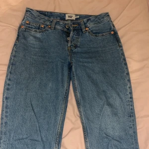 Lågmidjade Blå raka jeans från 157 - Klassiska blå jeans från 157 med raka ben och normal passform. Jeansen har fem fickor, knäppning med knappar och snygga kontrastsömmar. Perfekta för en avslappnad och stilren look.