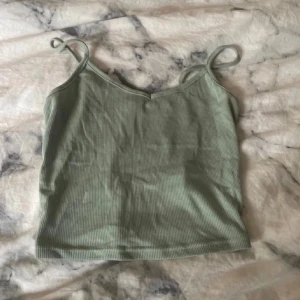 Ljusgrön ribbad linnetopp från SHEIN - Superfin ljusgrön ribbad linnetopp från SHEIN i storlek XS. Toppen har smala axelband och en lätt croppad passform. Perfekt för varma dagar och enkel att matcha med jeans eller kjol. Snygg och enkel basic som passar till allt.