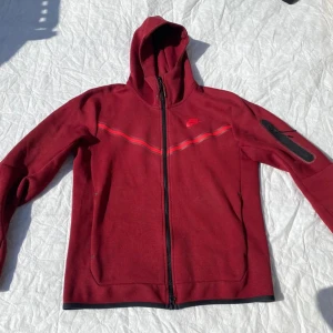 Nike tech - Nike Tech Fleece hoodie, stl S Vinröd, i fint skick. Dragkedja fram, huva och ficka på ärmen. Original.