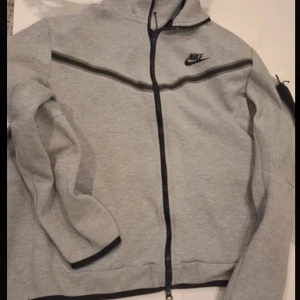Grå Nike tech fleece - Säljer min gråa Nike tech fleece eftersom den inte passar mig längre ingen fläck eller hål, inga skador!