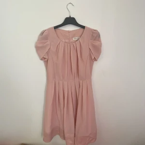 En rosa Kläning - En rosa klänning, längden går ungefär till knäna kanske lite längre de beror på hur lång man är jag är 157 och den går lite  under mina knän 