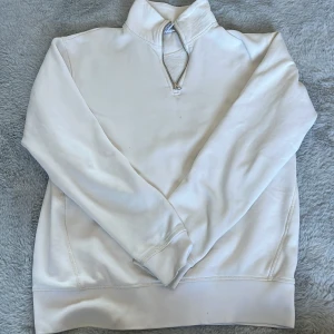 Vit halvzip sweatshirt från Zara - Säljer en stilren vit sweatshirt från Zara med halv dragkedja i halsen. Tröjan har lång ärm och hög krage, perfekt för en avslappnad och trendig look. Passar till det mesta och är superenkel att matcha med andra plagg.