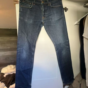 Mörkblå jeansbyxor från Nudie Jeans - Klassiska mörkblå jeans från Nudie Jeans med raka ben och femficksmodell. Passar perfekt till vardags och har en tidlös look.