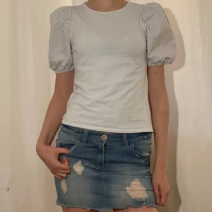 Ljus blå topp med puffärmar från H&M - Säljer en söt ljus blå topp från H&M med puffiga korta ärmar. Toppen har en rund halsringning och är tillverkad i ett mjukt bomulls material. Perfekt för en trendig och stilren look. Säljer den för att jag inte använder den så mycket! 💗💗💗