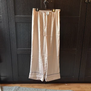 2-piece set siden pyjamas från H&M, aldrig använda och är i mycket bra skick! Båda är i storlek S - Fin 2-piece siden pyjamas i färgen beige, aldrig använda!