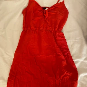 Röd kortklänning med knyt framtill - Säljer en jättesöt röd klänning. Klänningen har tunt och skönt material vilket är jättenajs på sommaren. Enkel och stilren design som passar till många tillfällen! Använd fåtal gånger 