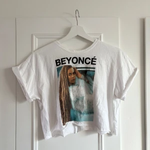 Vit Beyoncé t-shirt med tryck - Vit croppad t-shirt med stort Beyoncé-tryck framtill. Aldrig använd.