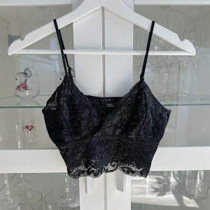 Svart kort spets topp 🖤 - En snygg svart kort spets topp med justerbara axelband i storlek S från Amisu, köpt secondhand och är använd 2 gånger. Det har blivit ett hål på ena sidan bysten, hände i tvätten men inget som syns om man inte tittar väldigt nära! FÖRST TILL KVARN!🖤(BUNDLERABATT VID KÖP AV FLER ARTIKLAR, KIKA MIN PROFIL!)