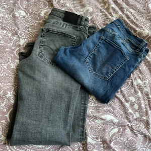 Två par jeans från Jack & Jones - Säljer två par jeans från Jack & Jones. Ett par grå jeans i modellen Tapered/Mike och ett par klassiska blå jeans i modellen Regular/Clark. Båda har femficksdesign och är perfekta för en avslappnad stil.