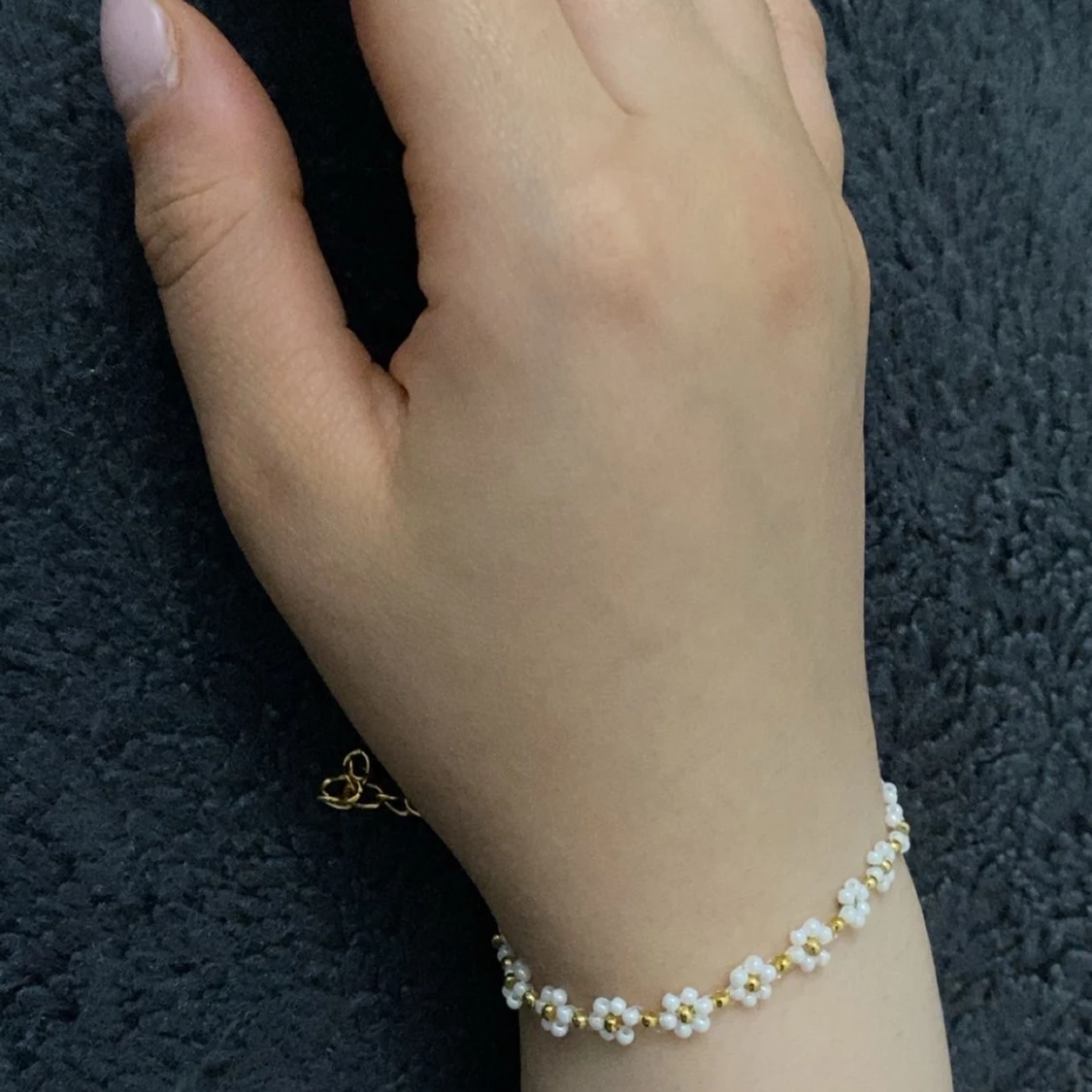 Blommigt armband med pärlor och gulddetaljer - 1