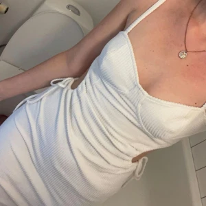 Vit korsettklänning nakd - Säljer den här otroligt fina vita korsettklänningen med utskurna partier i sidan, endast använd 2 gånger så i mycket fint skick!!💞