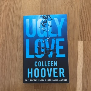 Ugly Love - En engelskspråkig roman av Colleen Hoover med blått omslag och stora bokstäver. Boken handlar om en oförglömlig kärlekshistoria som bryter mot alla regler. Perfekt för dig som gillar känslosamma berättelser.