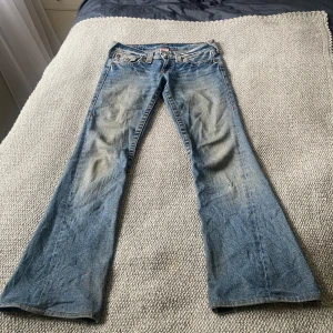 Blå true religion jeans joey - Bara använda 2 gånger, köpte de i nyskick för 899 kr här på vinted.🫶🏻 Säljer då de är för små.  - Innerbenslängd: 79 cm - Ben: 22 cm - Midja: 38 cm - Totallängd: 94 cm  De har några små defekter, vilka är följande: - Ett hål under knäet, som jag har sytt igen  - Ett hål över fickan  - Slitningar vid benen  Defekterna fanns när jag fick byxorna. 