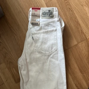 Vita Levi's SilverTab '94 Baggy jeans - Säljer ett par vita Levi's SilverTab '94 Baggy jeans med klassisk femficksdesign och raka ben. Byxorna har hög midja och är tillverkade i kraftig bomull. Perfekta för en avslappnad och trendig look. Helt nya med prislappen kvar 