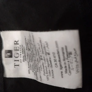 Svart jeansjacka från Tiger of Sweden - Snygg svart jeansjacka från Tiger of Sweden med klassisk passform. Jackan är tillverkad i bomull och har en cool dragkedja i metall längs ärmen samt fickor både fram och bak. Perfekt för dig som gillar stilrena detaljer och tidlös design.