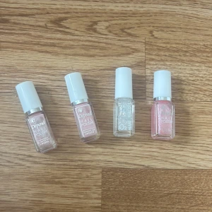 Fyra Depend nagellack i rosa och glitter - Säljer fyra snygga nagellack från Depend. Två i ljusrosa nyanser, ett med transparent glitter och ett i skimrande rosa. Alla kommer i små, rektangulära glasflaskor med vita korkar. 