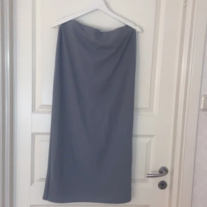 Grå/blå långkjol med slits från 157 - Snygg grå/blå långkjol från 157 i storlek M. Kjolen har en rak passform och en stilren slits baktill som ger extra rörelser frihet och har en lätt stretch den är från lager 157 i storlek M.