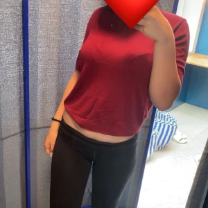 Vinröd stickad tröja från Divided H&M - Säljer en vinröd stickad tröja från Divided by H&M i storlek L. Tröjan har korta ärmar, rund hals och är croppad i modellen. Perfekt för dig som gillar enkel och stilren look med lite edge. Materialet är mjukt och skönt mot huden. Knappast använd 