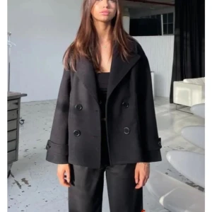 Design by si kappa - Stilren svart kappa från design by si, jag säljer pågrund av att den inte passar eller sitter bra på mig. Den är väldigt fräs men har lite noppror men inget som syns! Va inte rädd för att ställa frågor eller lägga prisförslag, så får jag önska er en fantastisk dag!❤️