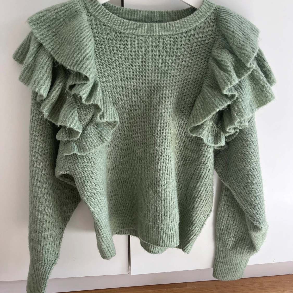 Grön stickad tröja med volanger - 1