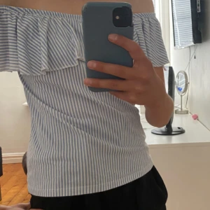 Blåvit offshoulder randig topp - Säljer en söt offshoulder topp från Cubus i blåvitt. Inget fel på toppen men tyget är ganska annvänt därav priset. 