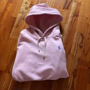 Ralph Lauren hoodie Rosa - En rosa Ralph Lauren hoodie i topp skick!! Den är använd två gånger då jag köpte fel storlek. Storlek M och priset ligger på 959 vilket är ett kap med tanke på att tröjan är i ny skick.