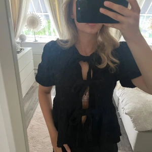Svart topp med knytning - Sparsamt använd topp från Gina Tricot. Den har knytning i mitten som man kan justera själv hur tajt man vill ha den. Superfin till alla typer av tillfällen. Skriv om du har några frågor eller vill ha fler bilder!💕🌸