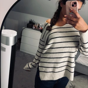 Vit och svart randig tröja H&M - Mysig vit tröja från H&M med svarta horisontella ränder. Tröjan har en loose passform, bred ribbad kant nedtill och vid ärmslut samt en något bredare halsringning. Materialet är mjukt och stickat, perfekt för kyliga dagar.