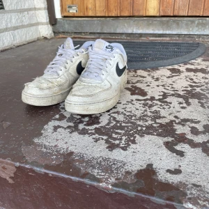 Nike Air Force 1 vita sneakers - Nike air force 1 vita med svart märke. Dem är ganska använda men om du bara vill ha ett par skor eller så kanske du tycker det är snyggt med slitna skor så är det bara att höra av sig 