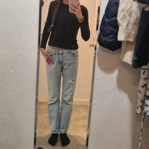 Ljusblå jeans - Säljer ett par ljusblå gina tricot jeans med raka ben och slitningar på låret. Jeansen har klassisk femficksdesign, låg midja. Storlek 164