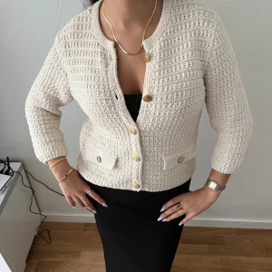 Beige stickad kofta från Zara  - Superfin beige stickad kofta från Zara med snygga guldknappar. Perfekt att slänga över en klänning eller topp för en chic look. Är i storlek S men passar som storlek M med! 💗