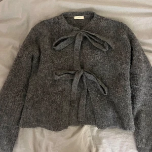 Grå kofta med knyt från Gina Tricot - Jätteskön och snygg grå kofta från Gina Tricot i storlek XS. Använd en gång, bra skick!