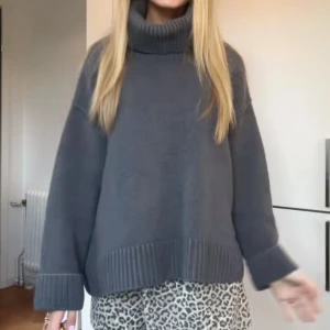 Mörkgrå stickad polotröja - Säljer en oversized mörkgrå stickad polotröja med bred ribbad kant vid ärmslut och nederkant. Tröjan har hög polokrage och långa ärmar, perfekt för lager-på-lager och chill höst- och vinterstil.