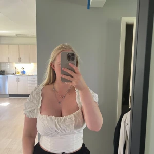 Vit croppad blus med puffärmar - Säljer en vit croppad blus med puffiga korta ärmar som kan bäras både på axlarna och offshoulder. Storlek 38, från h&m