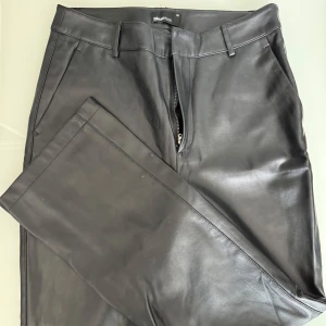 Svarta skinnbyxor från Gina Tricot - Svarta skinnbyxor i skinn från Gina Tricot. Bra skick.