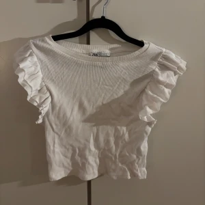 Vit ribbad topp med volangärm Zara - Supersöt vit ribbad topp från Zara med korta volangärmar.