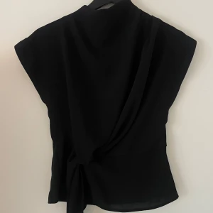 Svart omlott blus med knyt ifrån Zara -  svart blus med omlott-design och snyggt knyt i midjan. Ifrån zara