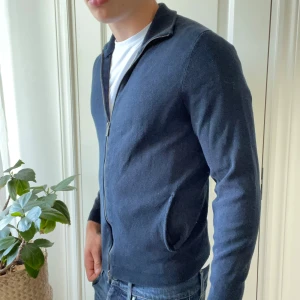 Massimo dutti full zip blå M - Massimo dutti full zip mörkblå, ganska urtvättad men inga riktiga defekter. Urtvättningen märks på hur kedjan böjer sig, det är lite extremt på den första bilden. Storlek S och modellen är 180,75 kg. 