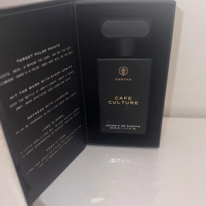 Oakcha Cafe Culture Extrait de Parfum - Parfymen Café Culture från Oakcha kommer i en stilren, svart rektangulär flaska med gulddetaljer och rymmer 50 ml. Extrait de Parfum med långvarig formula, vegansk och fri från parabener och ftalater. Doften är unisex och levereras i en elegant svart kartong. (Inspirerad av Byredo’s Vanille Antique)