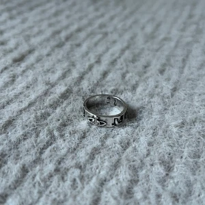 Éclat de Saturne - Elegant ring med intrikat flätad design och Saturnus-inspirerat motiv. Storlek 5.5