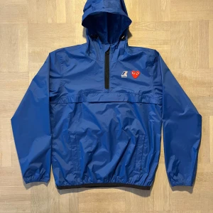Blå windbreaker K-Way x Comme des Garçons play - Tjena, säljer denna nå windbreaker från cdg play för ett riktigt bra pris. Använd 3-5 gånger känns direkt ur butik. Är öppen för frågor och förslag:)