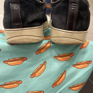 Blå sneakers från Lanvin i mocka och lack - Snygga blå sneakers från Lanvin med ovandel i mocka och detaljer i blankt lack. Skorna har rund tå, snörning och vit platt sula. Perfekta för dig som gillar en stilren men lyxig look med mix av material.   INTRESSEKOLL!!