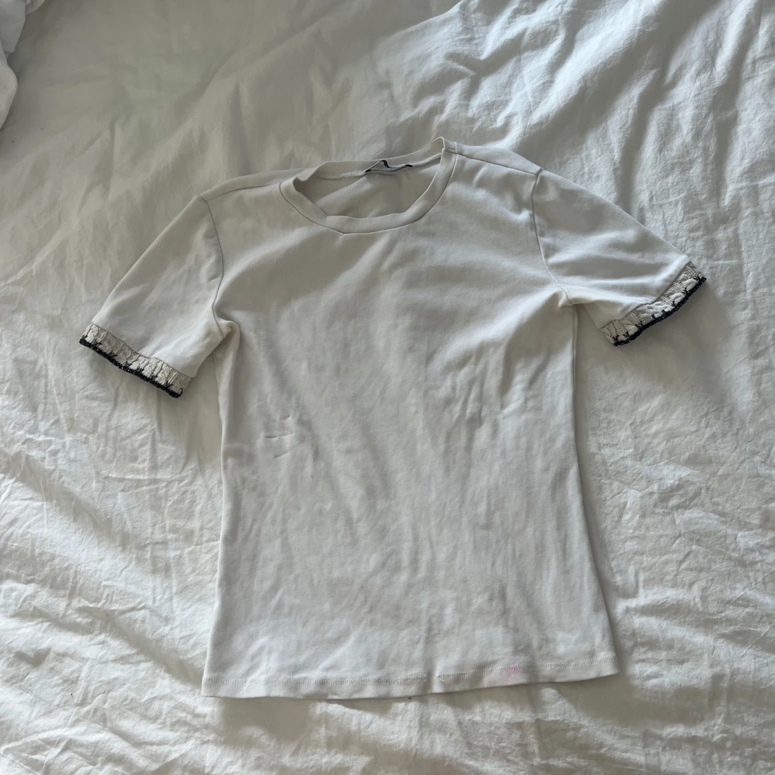 Vit topp med volangdetalj på ärmar