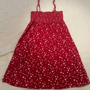 Röd sommarklänning med stjärnor från KappAhl  - Supersöt röd kortklänning från KappAhl med vita stjärnor över hela tyget. Storlek 158/164 men passar större storlekar skulle jag säga