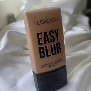 Huda Beauty Easy Blur Foundation 220N - Huda Beauty Easy Blur Foundation i nyansen Custard 220N. Ger en naturlig airbrush-effekt och innehåller 1,5% niacinamid. Kommer i en beige plastflaska med svart lock, 30 ml. Perfekt för dig som vill ha en jämn och flawless bas. 
