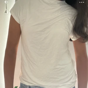 Vit  t-shirt från 157 lite annorlunda! - Enkel och stilren vit t-shirt från 157 med klassisk passform och rund hals. T-shirten är kortärmad och gjord i mjuk bomull, perfekt till jeans eller shorts. 
