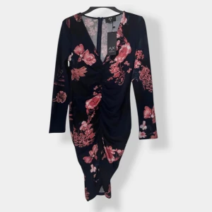 Mörkblommig långärmad klänning AX Paris - Supersnygg mörkblå klänning från AX Paris med rosa och röda blommor, v-ringning och rynkade detaljer framtill. Långärmad och figurnära passform, perfekt för dig som vill sticka ut. Dragkedja bak för enkel påklädning.